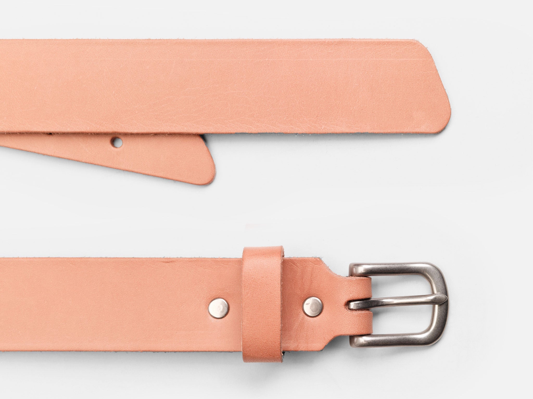 A close-up of a light tan leather belt with a silver buckle, displayed on a white background. The belt is laid out flat, showing both the buckle and the pointed end.